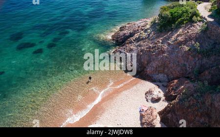 Una persona nella spiaggia di Aiguille a Théoule sur Mer sulla Costa Azzurra Foto Stock