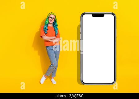 Foto di affascinante fidata giovane donna vibrante indossare occhiali t-shirt arancione sorridente braccia incrociate isolato sfondo di colore giallo Foto Stock