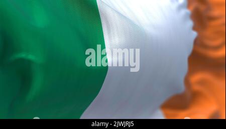 Vista ravvicinata della bandiera nazionale irlandese che sventola nel vento. L'Irlanda è un'isola nell'Oceano Atlantico settentrionale, nell'Europa nord-occidentale. Tessitura del tessuto Foto Stock
