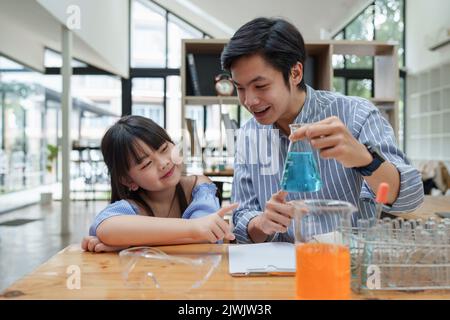 Bambino e insegnante che fanno esperimenti scientifici. Torna al concetto scolastico Foto Stock