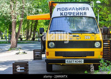 Consegna cibo. Furgone auto retrò parcheggiato nel parcheggio, vendita caffè, Russia. Veicolo divertente per il viaggio di vendita di snack. roadtrip con trasporto in furgone giallo. TR Foto Stock