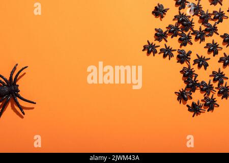 Primo piano di più giocattoli ragno con spazio copia su sfondo arancione Foto Stock