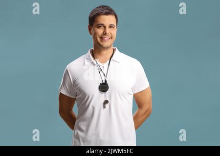 Allenatore di nuoto con un wistle e cronometro intorno al collo isolato su sfondo blu Foto Stock