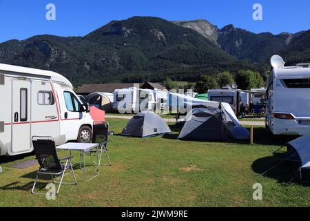 SANKT GILGEN, AUSTRIA - 3 AGOSTO 2022: Camper e tende in un campeggio vicino al lago Wolfgangsee, nella regione austriaca del Salzkammergut. Foto Stock