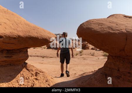 Giovane donna che esplora gli hoodoos al Goblin Valley state Park Foto Stock