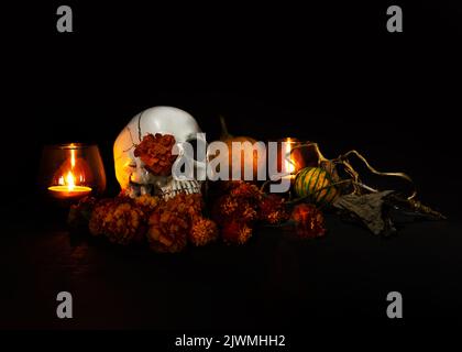 Cranio, candele ardenti e fiori di colore arancione su sfondo nero. Concetto di dia de los muertos giorno o giorno dei morti. Banner Halloween scuro. Foto Stock