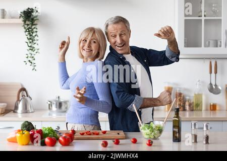 Marito e moglie senior divertenti mentre cucinano Foto Stock