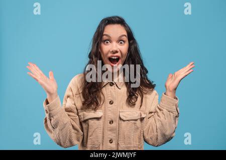 Espressione facciale. Scioccato giovane studentessa europea di brunette in casual con bocca aperta Foto Stock