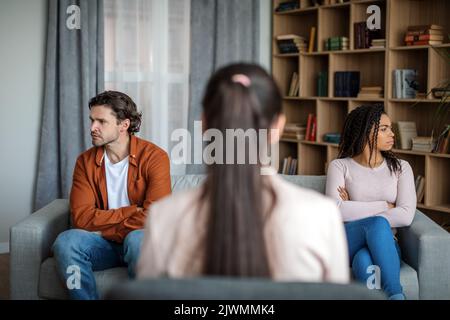 Arrabbiato giovane moglie nera ignora marito caucasico a incontrare il medico psicologo Foto Stock