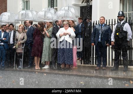 Il Segretario di Stato per il lavoro e le pensioni, Theresa Coffey e No10 dipendenti si rifugiano da una crisi mentre attendono che il nuovo primo ministro Liz Truss arrivi a Downing Street, Londra, dopo aver incontrato la regina Elisabetta II e aver accettato il suo invito a diventare primo ministro e a formare un nuovo governo. Data immagine: Martedì 6 settembre 2022. Foto Stock