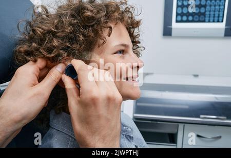 ENT o pediatra che fa un esame professionale dell'orecchio del paziente del bambino nell'ufficio medico presso la clinica medica. Esame delle orecchie dei bambini Foto Stock