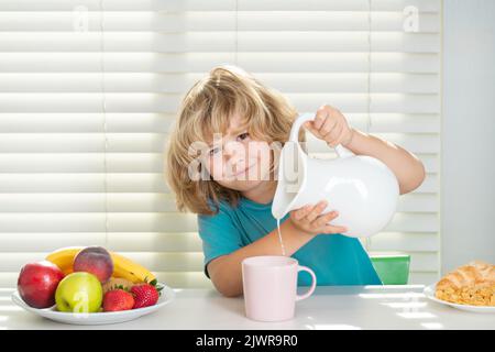 Capretto che versa latte intero di mucche. Capretto che mangia le verdure sane dell'alimento. Colazione con latte, frutta e verdura. I bambini mangiano a pranzo o a cena. Foto Stock