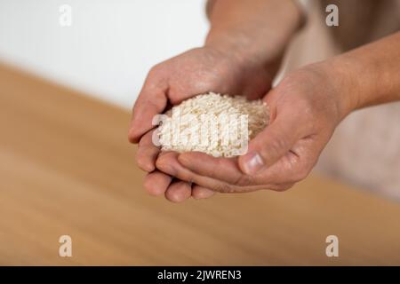 Uomo irriconoscibile mani con manciata di riso Foto Stock