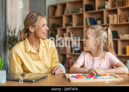 Formazione vocale per i bambini. Professionista femmina specialista di formazione con la ragazza, insegnare bambino diritto articolazione esercizi Foto Stock