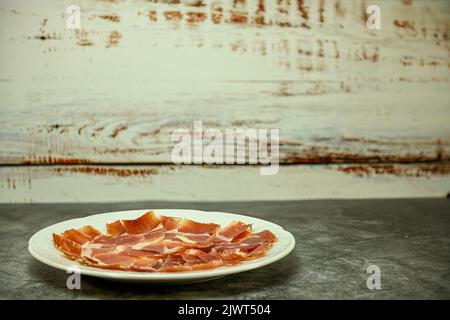 Piatto di prosciutto di Serrano, tagliato di fresco e servito su un piatto. Foto Stock