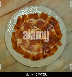 Piatto di prosciutto di Serrano, tagliato di fresco e servito su un piatto. Foto Stock