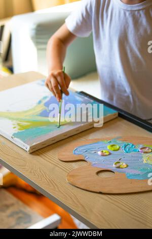 Pittura bambino su tela con pittura acrilica. Foto Stock
