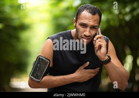 Giovane afro-americano che ha un attacco di cuore, chiama ambulanza Foto Stock