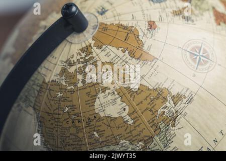 Primo piano del Canada su un globo geografico fisico rotante. Modello di messa a terra su un supporto. Foto di alta qualità Foto Stock