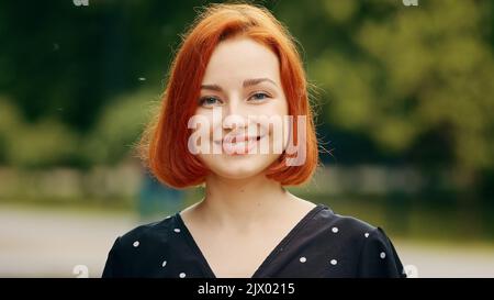 Primo piano esterno ritratto di faccia femmina umana ragazza caucasica giovane rossa donna donna donna sorridente fuori annuire testa sì risposte approvazione segno d'accordo Foto Stock