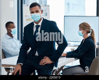 Uomo d'affari con maschera facciale covid in riunione, leader in officina di formazione e coaching dipendenti in conformità con le regole e le normative sul lavoro Foto Stock