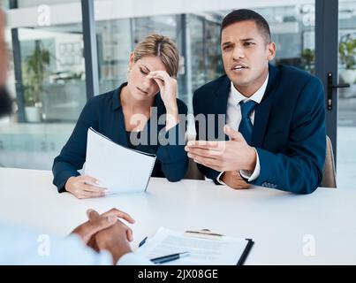 Avvocato che parla in un ufficio mentre il cliente di sforzo legge il documento mentre parla con il CEO o il capo dell'azienda, professionista legale. Consigliere che negozia un Foto Stock