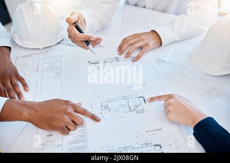 Team di architettura, BluePrint e Engineering che indica, pianifica e discute il progetto di sviluppo delle costruzioni con la planimetria. Collaborazione Foto Stock