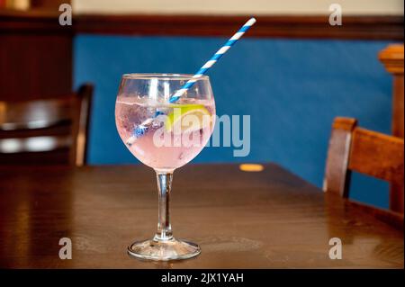 Bicchiere di gin e tonico cocktail colorato servito nel vecchio pub Scottisch d'epoca, bevendo gin a Edimburgo, Regno Unito Foto Stock