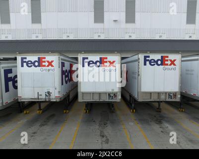 Vista in primo piano dei rimorchi FedEx mentre sono attraccati presso un terminal di spedizione Federal Express; il logo FedEx è visibile su ciascun rimorchio. Foto Stock