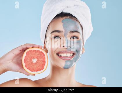 Donna, cura della pelle e pompelmo maschera viso, bellezza organica e benessere per il viso sano, viso fresco e pelle naturale pulita e luminosa su sfondo blu Foto Stock