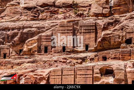 Rock Tombs Jordan Flag Morning Street of facades Petra Jordan Costruito da Nabataens nel 200 a.C. a 400 d.C. le pareti del canyon cambiano Rose Red pomeriggio quando il sole g Foto Stock