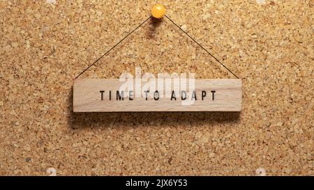 Tempo di adattare parola scritta su superficie di legno. Appeso su tavola di legno. Lavoro ed educazione Foto Stock