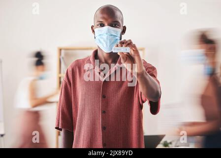 Covid, test antigenico rapido e maschera facciale mentre si è in piedi e mostrando risultati medici negativi. Ritratto di un uomo nero che si guarda felice dopo coronavirus Foto Stock