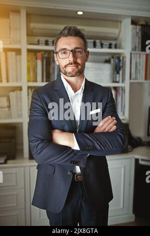 HES un uomo d'affari moderno ed elegante. Ritratto di un uomo d'affari in piedi nel suo ufficio. Foto Stock