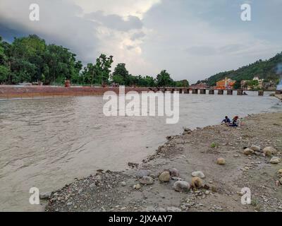 Giugno 17th 2021 Haridwar Uttarakhand India. Persone sedute sulle rive del fiume Ganges durante il monsone. Acqua fangosa durante monsone Foto Stock