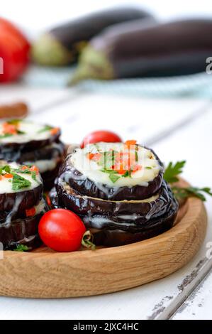 Melanzane al forno, pomodori e formaggio sul tavolo. Vista verticale Foto Stock