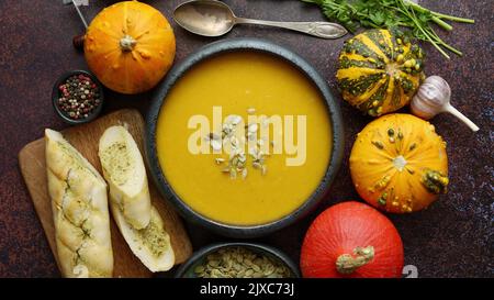 Deliziosa zuppa di zucca con semi di Sumflower crema e toast all'aglio su fondo arrugginito scuro Foto Stock