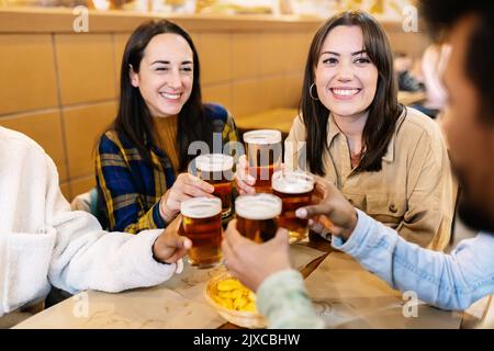 Gruppo di giovani amici felici che si gustano un drink al pub bar birreria Foto Stock