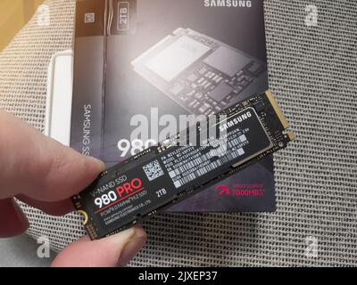 Parigi, Francia - 8 agosto 2022: Mano POV maschio disimballaggio disimballaggio nuovo Samsung 980 Pro NVME ss disco rigido per il personal computer o mac aggiornamento Apple Foto Stock