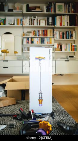 Parigi, Francia - 16 luglio 2022: Immagine verticale della scatola di cartone del nuovo aspirapolvere cordless a batteria da Dyson V12 slim Absolute con ripiani in Vitsoe sullo sfondo Foto Stock