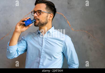 Fumatori e vaping può essere malsana e coinvolgente e rappresentano un rischio per la salute dei polmoni Foto Stock