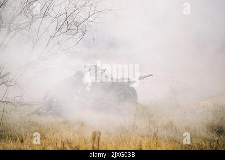 Re-enactors vestito come Wehrmacht tedesco Wehrmacht soldati di fanteria combattendo in modo difensivo con il supporto Anti-Tank Gun. Pistola anticarro tedesca che Foto Stock