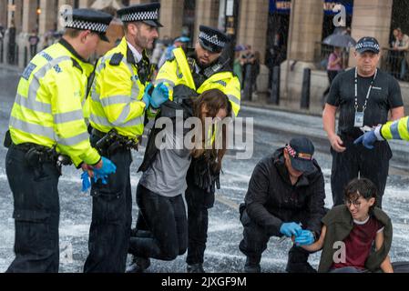 Westminster Bridge Road, Westminster, Londra, Regno Unito. 7th Set, 2022. I manifestanti vegani della ribellione animale hanno spruzzato vernice bianca su un muro del Palazzo di Westminster e bloccato la strada di Bridge Street all'esterno poco prima che il nuovo primo ministro Liz Truss arrivasse al Parlamento per le PMQ. Sono stati effettuati arresti. Protesta contro il latte. La pioggia pesante poco dopo ha lavato la maggior parte della vernice attraverso i marciapiedi e nella strada Foto Stock