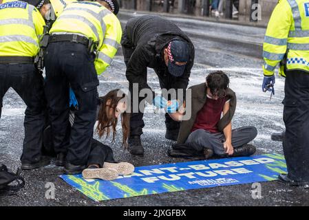 Westminster Bridge Road, Westminster, Londra, Regno Unito. 7th Set, 2022. I manifestanti vegani della ribellione animale hanno spruzzato vernice bianca su un muro del Palazzo di Westminster e bloccato la strada di Bridge Street all'esterno poco prima che il nuovo primo ministro Liz Truss arrivasse al Parlamento per le PMQ. Sono stati effettuati arresti. Protesta contro il latte. La pioggia pesante poco dopo ha lavato la maggior parte della vernice attraverso i marciapiedi e nella strada Foto Stock