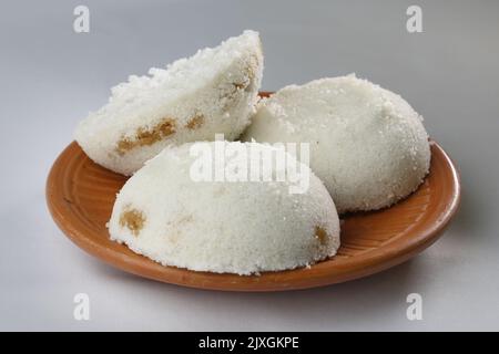 La torta di riso al vapore o il Bhapa Pitha è un piatto tradizionale del Bangladesh. Inverno Vapa Pitha spuntini su piatto di argilla. Foto Stock