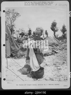 Assistente all'Ufficio meteorologico e al Forecaster dell'esercito del 7th nello Squadrone meteorologico dell'esercito, lavando Un asciugamano nel suo casco in un campo d'aviazione sull'isola di Anguat, sull'isola di Caroline. 12 ottobre 1944. Foto Stock