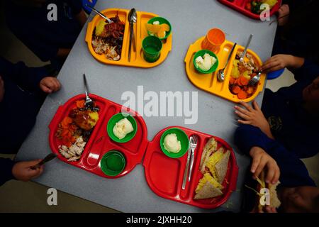Gli studenti mangiano il pranzo nella mensa scolastica durante l'inizio dell'introduzione dei pasti universali gratuiti per i bambini della scuola elementare a Ysgol Y Preseli in Pembrokeshire. La maggior parte degli studenti di accoglienza in Galles inizierà a ricevere pasti scolastici gratuiti quando torneranno a scuola a settembre. Il regime, che costituisce uno degli elementi dell'accordo di cooperazione tra il governo gallese e Plaid Cymru, dovrebbe essere pienamente implementato entro il 2024. Data immagine: Mercoledì 7 settembre 2022. Foto Stock