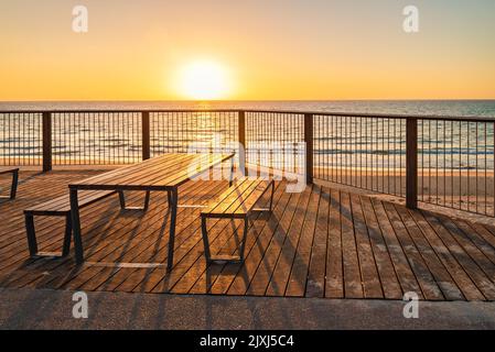 Tavolo da picnic sulla spiaggia al tramonto, Somerton Park, South Australia Foto Stock