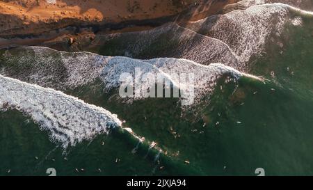 Splendida vista sul mare e sull'oceano con i surfisti in attesa delle onde. Foto Stock