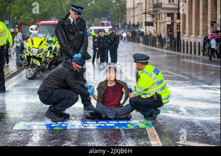 Londra, Regno Unito. 7th Set, 2022. Ribellione animale falsa protesta del latte al di fuori delle Camere del Parlamento e sovrapponendo le mani a Bridge Road per sconvolgere il traffico. La polizia rimuove i manifestanti nelle docce a pioggia pesanti. Credit: JOHNNY ARMSTEAD/Alamy Live News Foto Stock